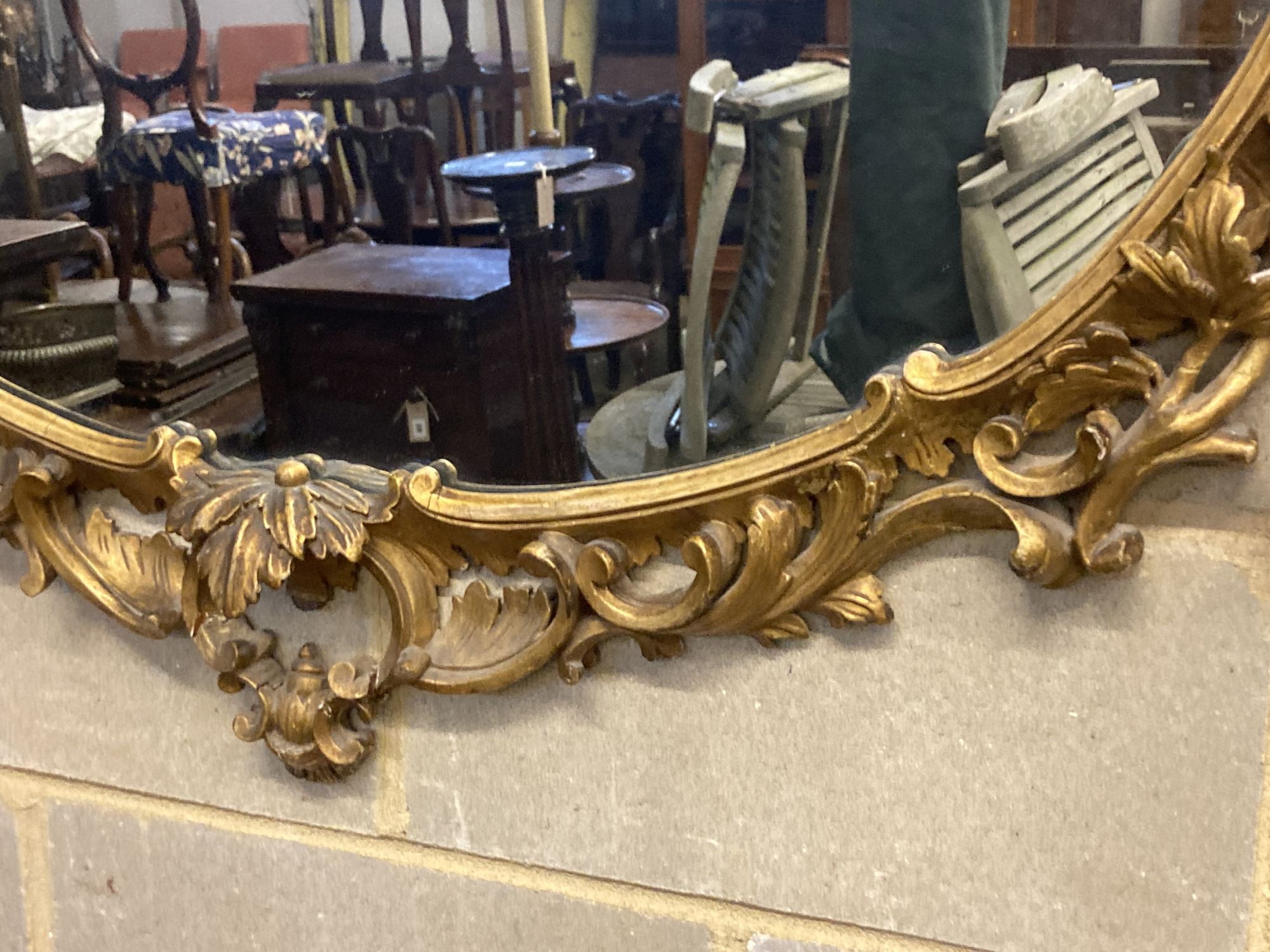 A Victorian ornate gilt oval wall mirror, width 110cm height 100cm